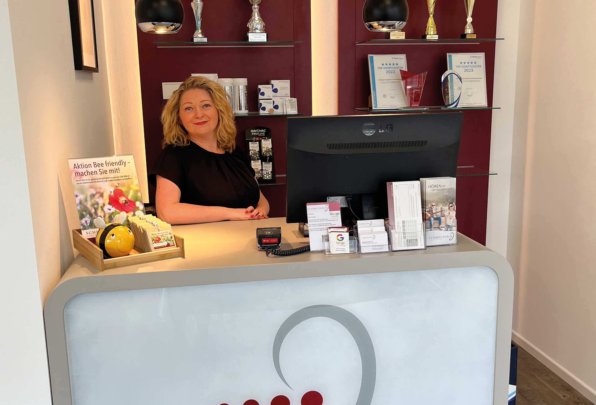 Mitarbeiterin steht am Empfangstresen